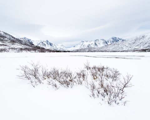 Snow-covered lake surrounded by mountains